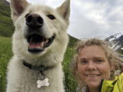 Amelia Milling is seen June 19 with a 7-year-old Alaskan husky named Nanook that is credited with helping rescue her when she was injured while hiking a trail in the Chugach State Park east of Anchorage, Alaska. She says the dog found her after she tumbled down a slope.