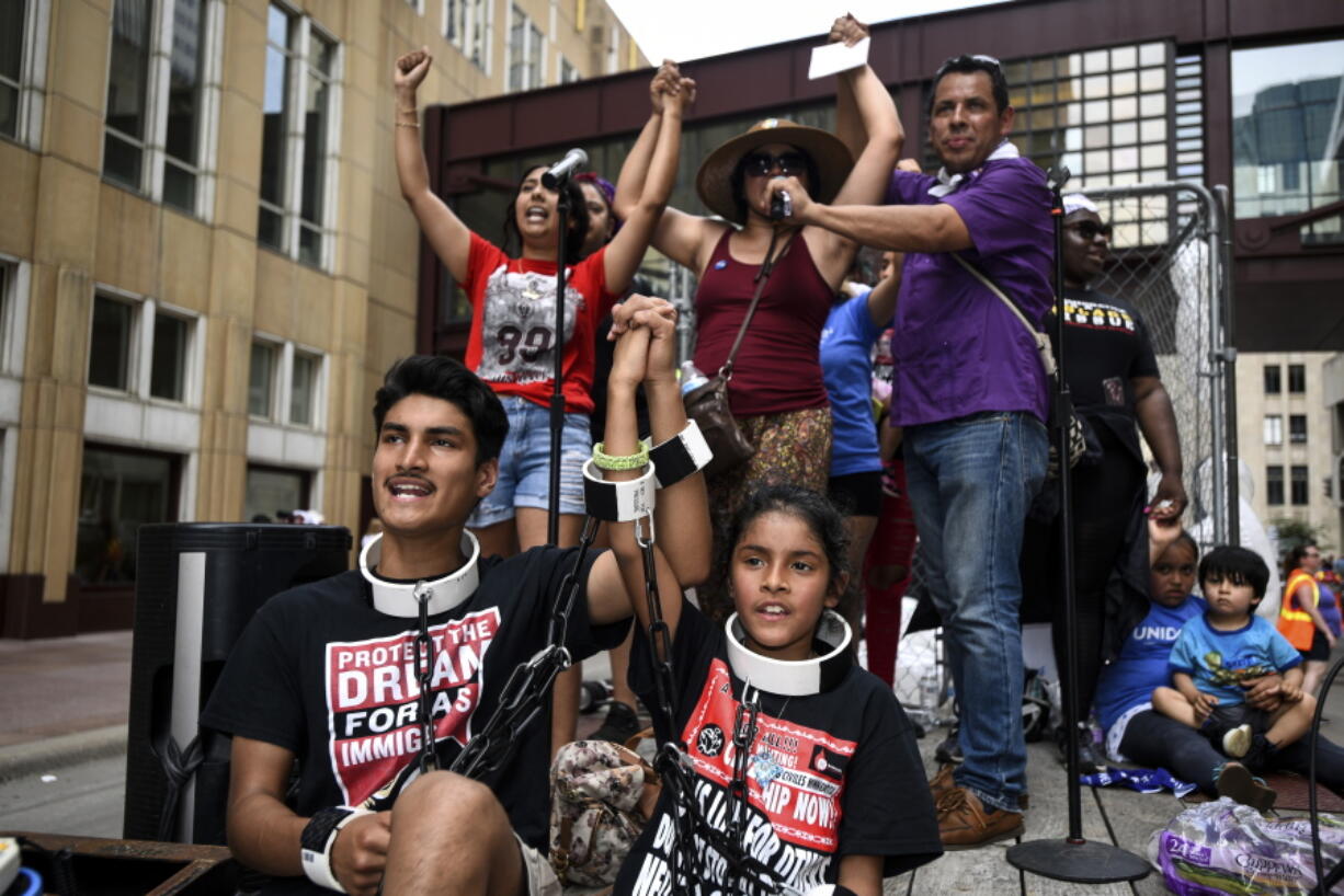 James Gutierrez, 15, and his sister, Lilah, 8, wore chains during a demonstration against the Trump administration’s immigration policies Saturday, June 30, 2018.(Aaron Lavinsky/Star Tribune via AP)