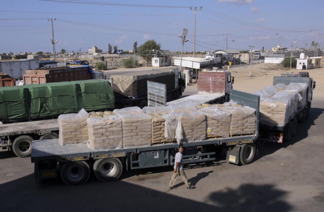 A Palestinian worker walks next to trucks loaded with sacks of cement at the Kerem Shalom border crossing on its way from Israel to Rafah in the southern Gaza Strip. Israel shut down the cargo crossing of Kerem Shalom with the Gaza Strip on Tuesday in response to continued Hamas hostilities, even after it agreed to a cease-fire ending 24 hours of intense fighting.