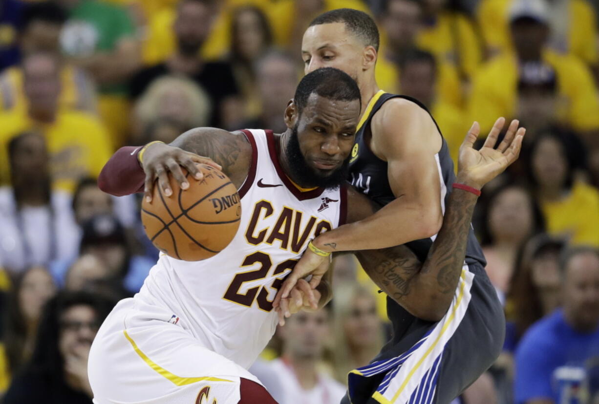 FILE - In this June 3, 2018, file photo, Cleveland Cavaliers forward LeBron James (23) drives against Golden State Warriors guard Stephen Curry during the first half of Game 2 of basketball's NBA Finals in Oakland, Calif. James is signing as a free agent with the Los Angeles Lakers, leaving the Cavaliers for the second time to join one of the NBA’s most iconic franchises. James made the announcement Sunday, July 1, 2018, on a release, saying he has agreed to a four-year, $154 million contract.