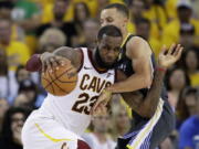 FILE - In this June 3, 2018, file photo, Cleveland Cavaliers forward LeBron James (23) drives against Golden State Warriors guard Stephen Curry during the first half of Game 2 of basketball's NBA Finals in Oakland, Calif. James is signing as a free agent with the Los Angeles Lakers, leaving the Cavaliers for the second time to join one of the NBA’s most iconic franchises. James made the announcement Sunday, July 1, 2018, on a release, saying he has agreed to a four-year, $154 million contract.