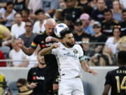 Los Angeles FC defender Laurent Ciman, left, of Belgium, and Portland Timbers midfielder Diego Valeri, center, of Argentina, battle for a head ball in the second half of an MLS soccer game in Los Angeles, Sunday, July 15, 2018. The game ended in a 0-0 draw. (AP Photo/Ringo H.W.