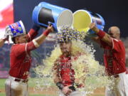 Los Angeles Angels’ Kole Calhoun, center, is doused by Jose Briceno, left, and Albert Pujols, and showered with bubble gum by another player, after hitting a walk-off home run during the 10th inning of a baseball game against the Seattle Mariners on Friday, July 27, 2018, in Anaheim, Calif. The Angels won 4-3. (AP Photo/Mark J.