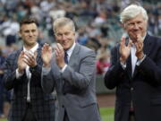 Seattle Mariners general manager Jerry Dipoto, left, president Kevin Mather, center, and majority owner John Stanton.