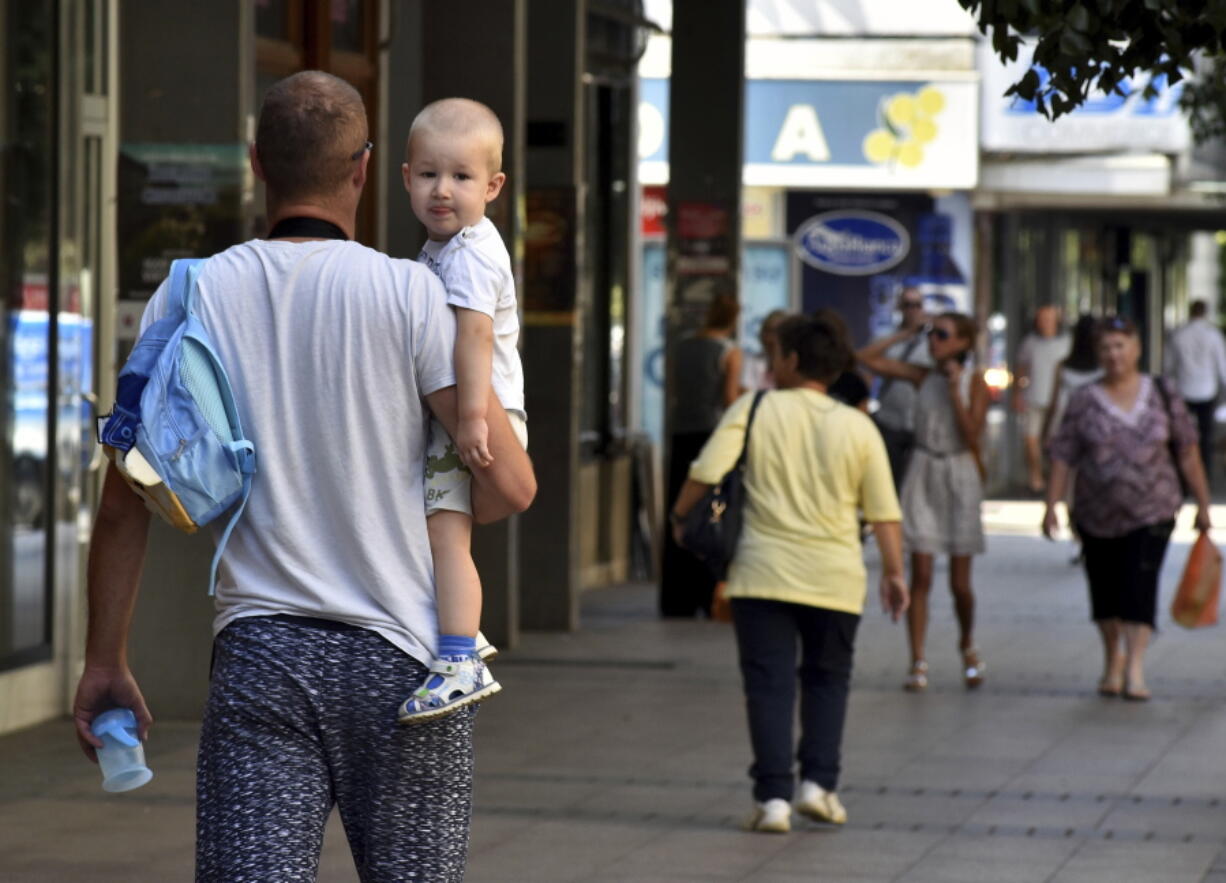 People walk along a street Thursday in Montenegro’s capital, Podgorica.