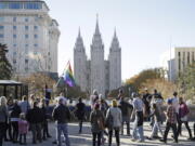 FILE - In this Nov. 14, 2015, file photo, people walk past the Salt Lake Temple after mailing resignation letters during a mass resignation from the Church of Jesus Christ of Latter-day Saints in Salt Lake City. The Mormon church’s massive genealogical database will begin accepting submissions of names of people from same-sex relationships sometime next year. The move doesn’t foreshadow any change to long-standing church opposition to gay marriage, but it is being done to ensure the databank has as much information as possible for researchers, according to a statement from The Church of Jesus Christ of Latter-day Saints.