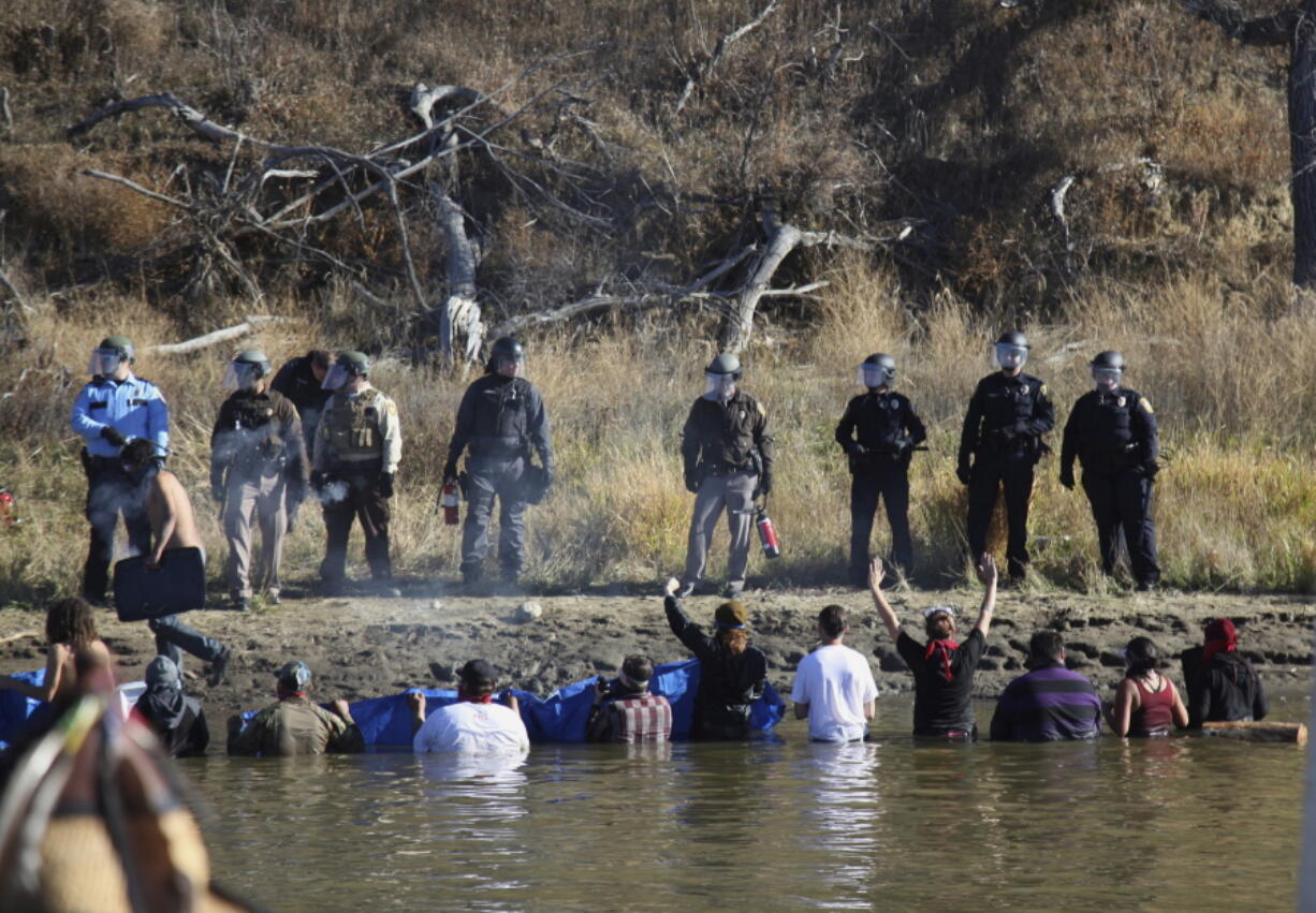 Protesters and police on Nov. 2, 2016, near Cannon Ball, N.D. North Dakota is demanding $38 million from the federal government to reimburse the state for costs associated with policing protests against the expansion of the Dakota Access oil pipeline.