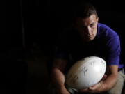 Washington quarterback Jake Browning hands the ball to head coach Chris Petersen, not pictured, in a holding room at the Pac-12 Conference NCAA college football media day in Los Angeles, Wednesday, July 25, 2018. (AP Photo/Jae C.