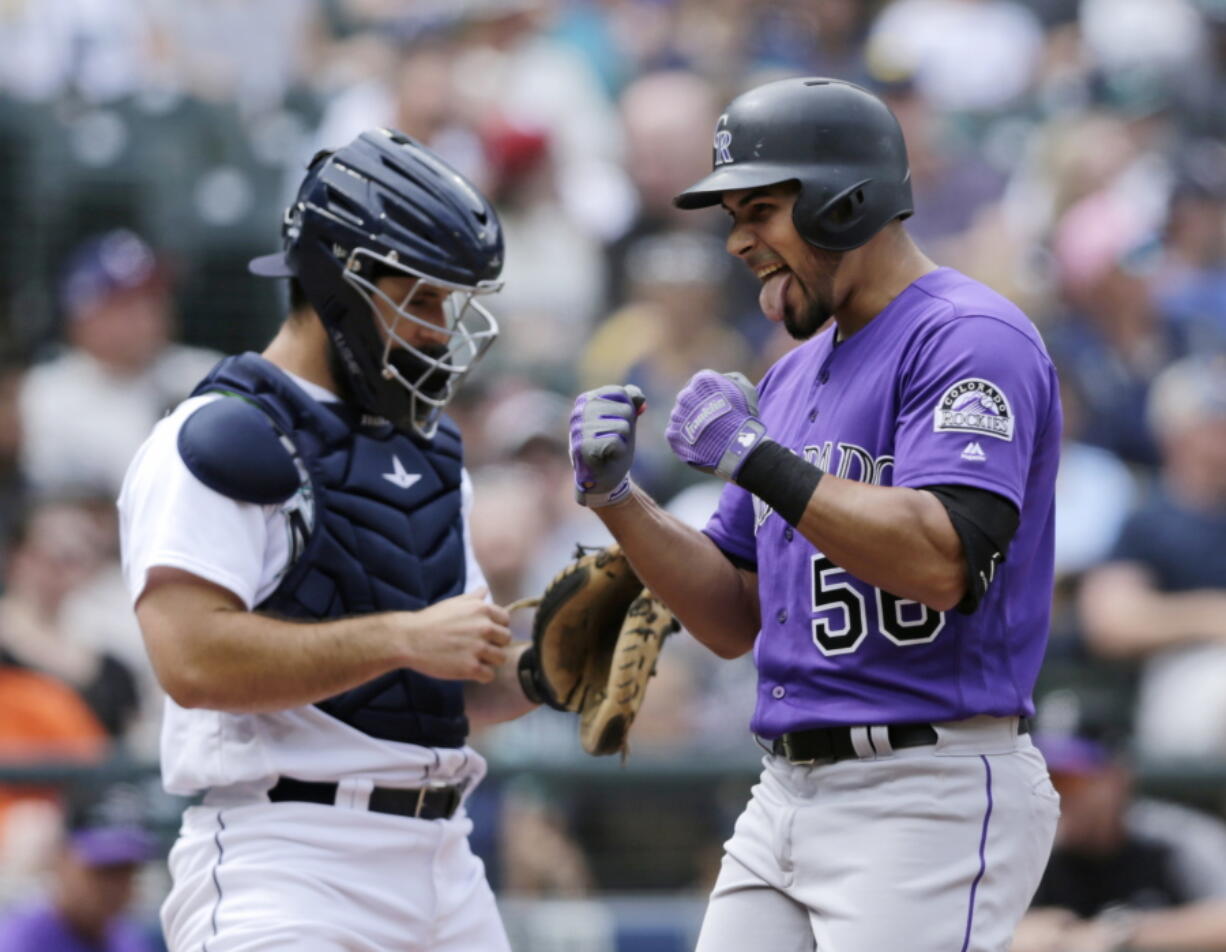 Colorado Rockies’ Noel Cuevas, right, celebrates as he reaches home after hitting a three-run home run on a pitch from Seattle Mariners starter James Paxton during the seventh inning of a baseball game, Saturday, July 7, 2018, in Seattle.