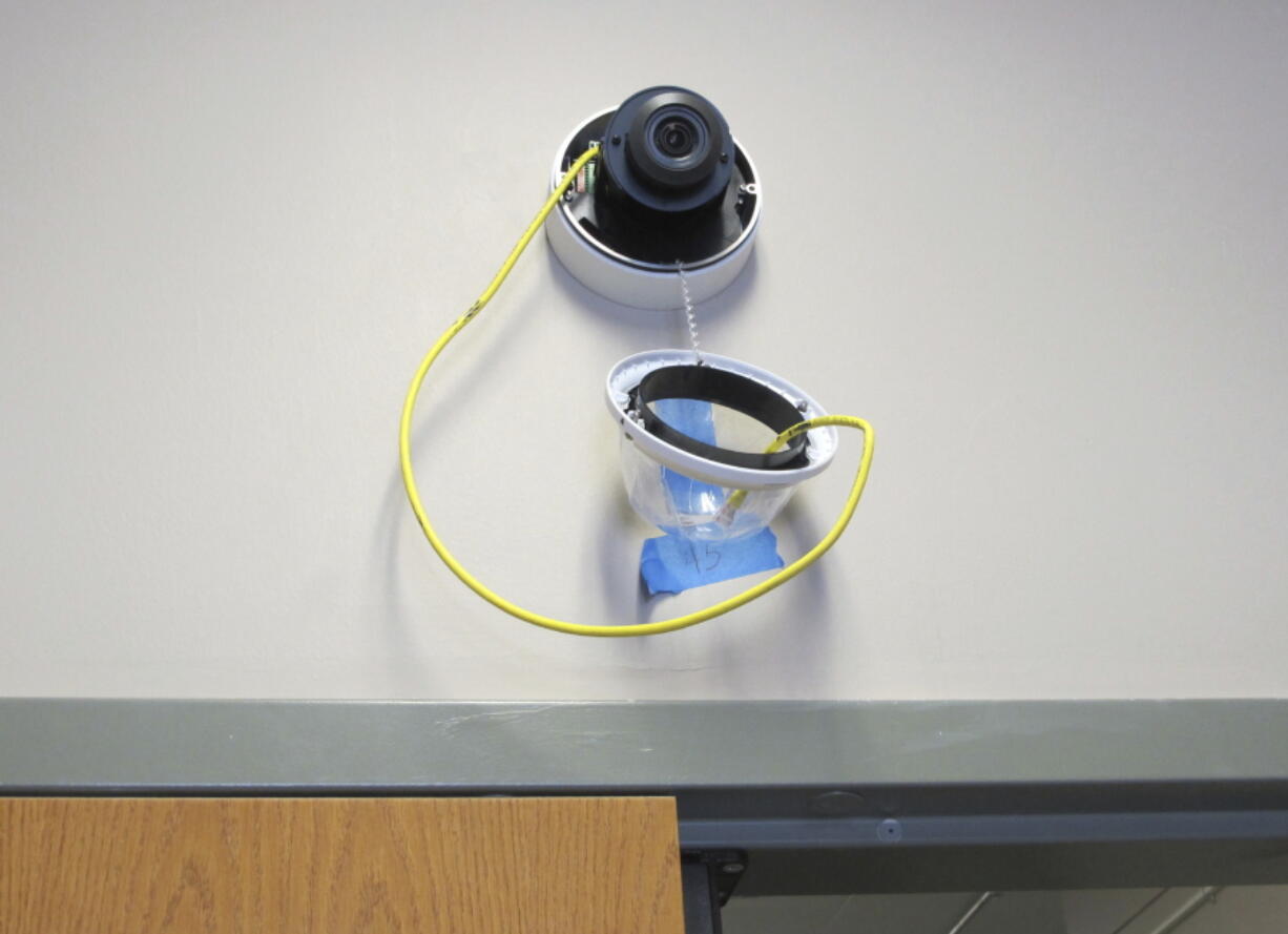 In this July 10 photo, a camera with facial recognition capabilities hangs from a wall while being installed at Lockport High School in Lockport, N.Y. The district is upgrading its surveillance system to add new technology.