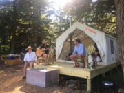 Michael D’Agostino, right, sits with Robert and Sally McCracken on June 29 at their Tentrr campsite in Sand Lake, N.Y. D’Agostino, CEO of Tentrr, says it’s like Airbnb or Uber for the great outdoors, providing a platform for landowners to earn some cash by sharing secluded and scenic sites for camping.