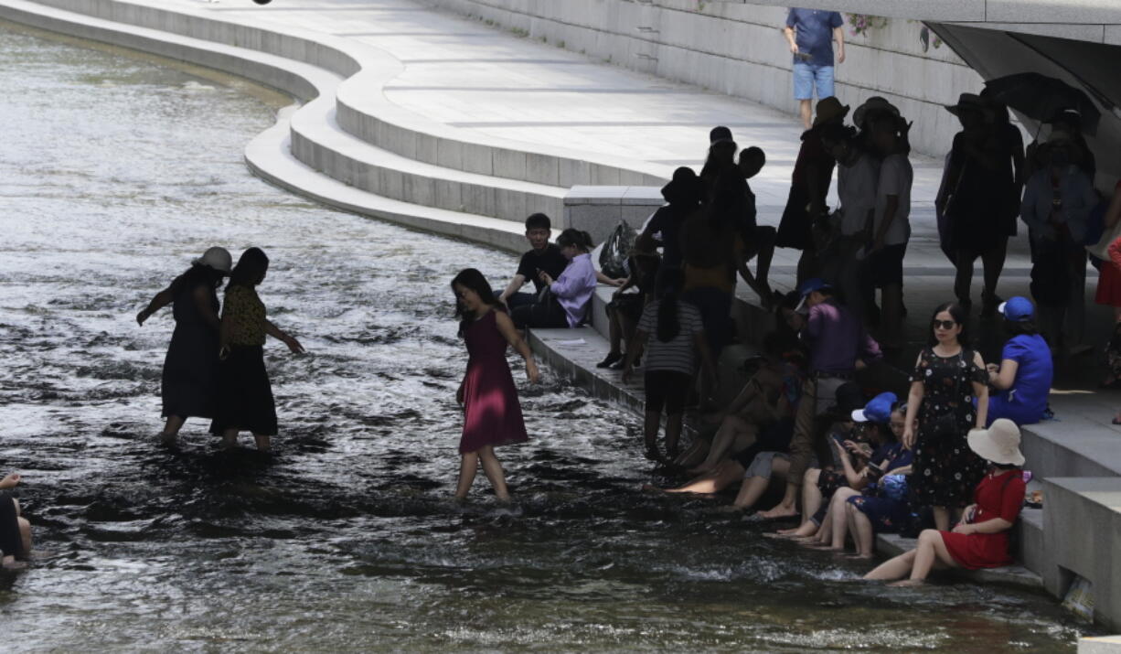 Visitors rest in the shade in the midday heat at Cheonggye stream in downtown Seoul, South Korea, Monday, July 23, 2018. The temperature in a city north of Tokyo reached 41.1 degrees Celsius (106 degrees Fahrenheit) on Monday, the highest ever recorded in Japan, as a deadly heat wave gripped a wide swath of the country and nearby South Korea.