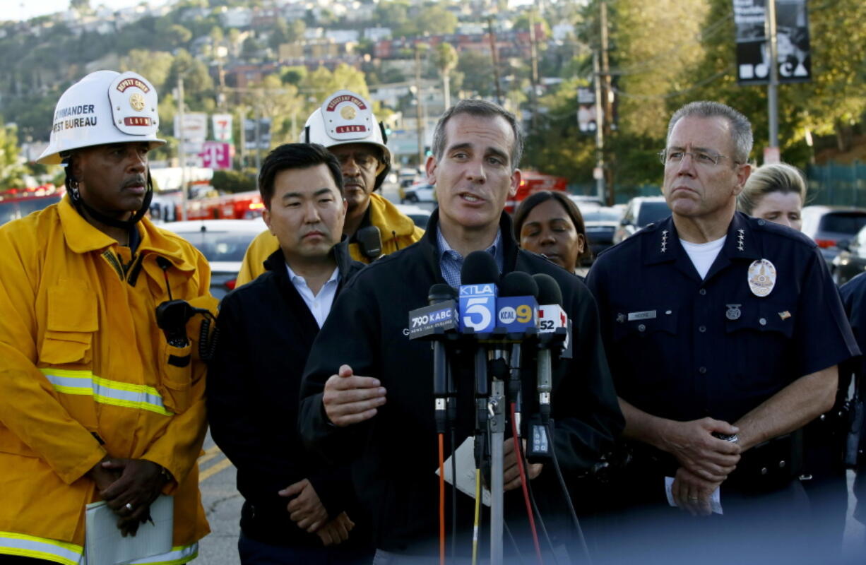 Los Angeles Mayor Eric Garcetti, center, and Police Chief Michel Moore, right, brief the media at a news conference after a gunman held dozens of people hostage inside a Trader Joe's supermarket before surrendering to police in Los Angeles on Saturday.