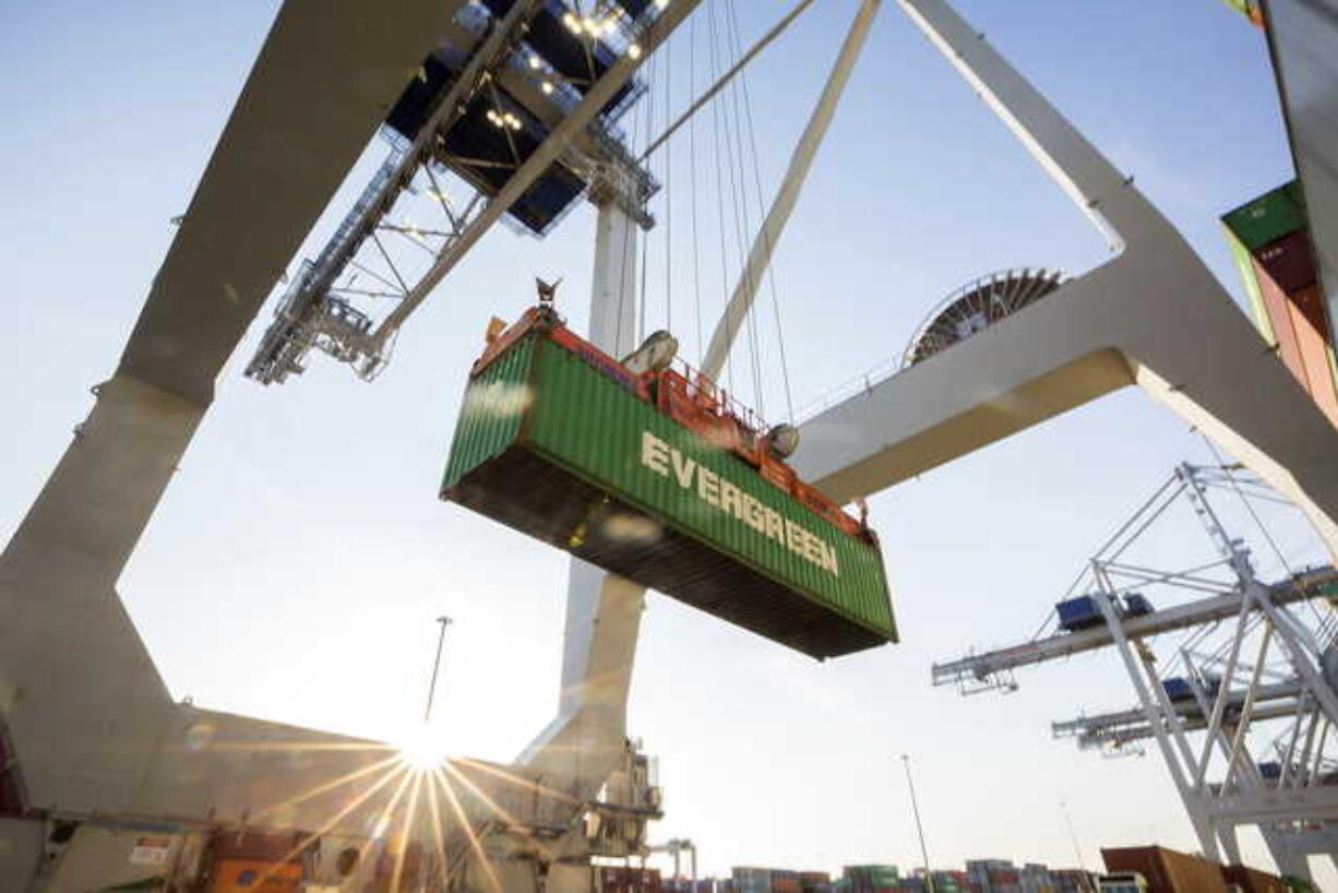 In this June, 19, 2018 photo, a ship to shore crane lifts a 40-foot Evergreen Line shipping container off a jockey truck onto a container ship at the Port of Savannah in Savannah, Ga. The U.S. has threatened to impose 25 percent duties on $34 billion in Chinese products starting Friday, July 6, and China has said it will fire back with corresponding tariffs. (AP Photo/Stephen B.