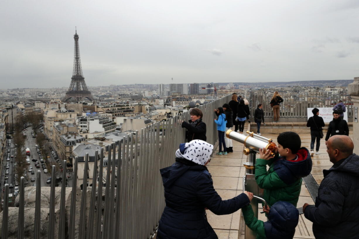 Tourists watch Paris on March 21, 2017 from the top of the Arc de Triomphe in Paris, France. The Eiffel Tower is seen background. The American Society of Travel Agents is starting to refer to agents as ‘travel advisers’ to better describe their emerging roles as trip planners rather than just booking agents. ASTA says they can add value to trips by finding freebies, perks and upgrades along with offbeat and authentic itineraries.