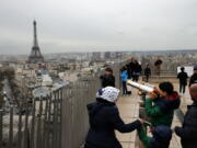 Tourists watch Paris on March 21, 2017 from the top of the Arc de Triomphe in Paris, France. The Eiffel Tower is seen background. The American Society of Travel Agents is starting to refer to agents as ‘travel advisers’ to better describe their emerging roles as trip planners rather than just booking agents. ASTA says they can add value to trips by finding freebies, perks and upgrades along with offbeat and authentic itineraries.