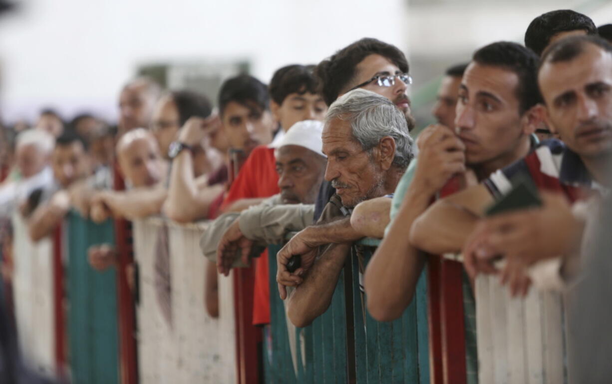 File-This May 22, 2018, file photo shows Palestinian passengers waiting to cross the border to the Egyptian side of Rafah crossing with Egypt, in Khan Younis, in the Gaza Strip. The United Nations is imploring member countries to fill a critical funding gap the Trump administration created by cutting $300 million that helped struggling Palestinian refugees across the Middle East. On Monday, June 25, 2018, the U.N. is holding a pledging conference to raise money for the most basic needs of 5 million refugees in the Gaza Strip, the West Bank, Jordan, Lebanon and Syria.