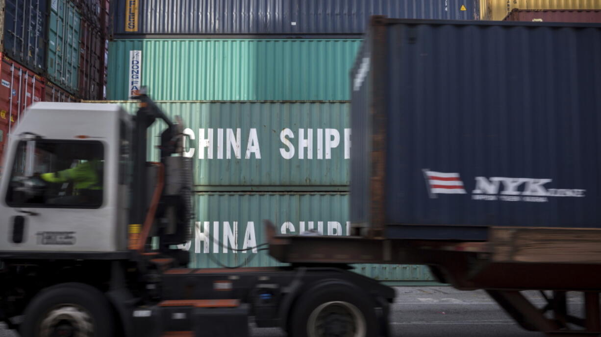 In this Thursday, July, 5, 2018 photo, a jockey truck passes a stack of 40-foot China Shipping containers at the Port of Savannah in Savannah, Ga. The United States and China launched what Beijing called the "biggest trade war in economic history" Friday, July 6, imposing tariffs on billions of dollars of each other's goods amid a spiraling dispute over technology. (AP Photo/Stephen B.