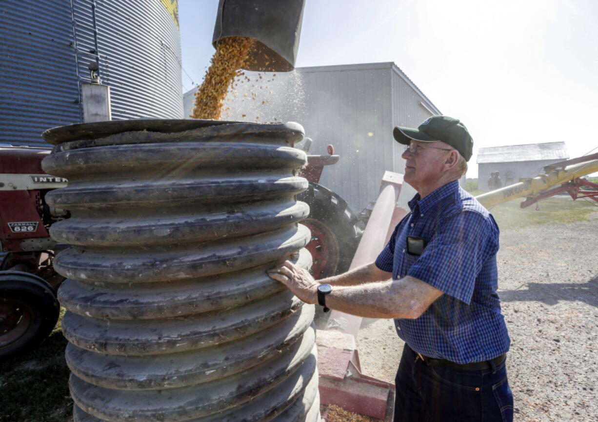 Don Bloss checks on the operation of an auger July 12 transferring corn on his farm in Pawnee City, Neb.