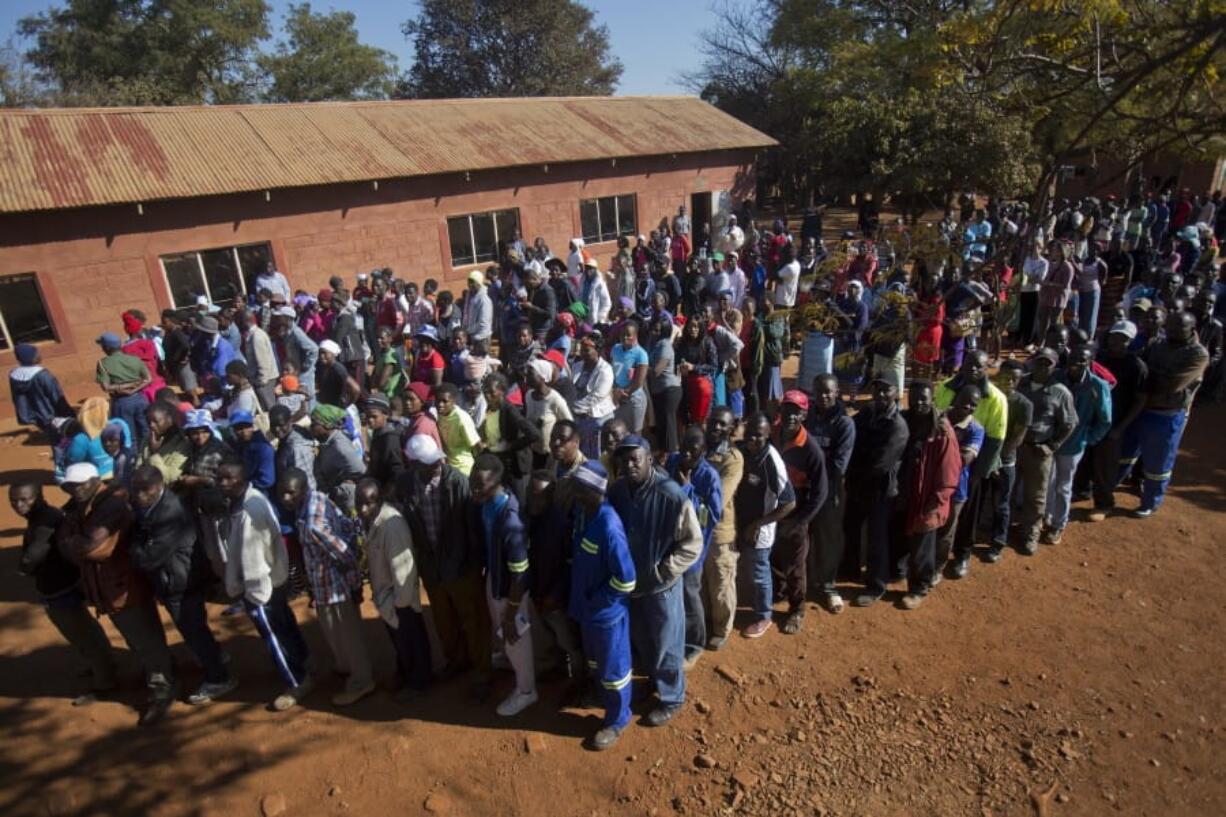 Zimbabweans queue as they wait to vote at the Sherwood Primary School in Kwekwe, Zimbabwe, on Monday. The vote will be a first for the southern African nation following a military takeover and the ousting of former longterm leader Robert Mugabe.