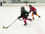 Max Gudanis, 10, sprints toward the goal, with Trenton Dodd, 11, in pursuit during a pickup hockey game Sunday at Mountain View Ice Arena.