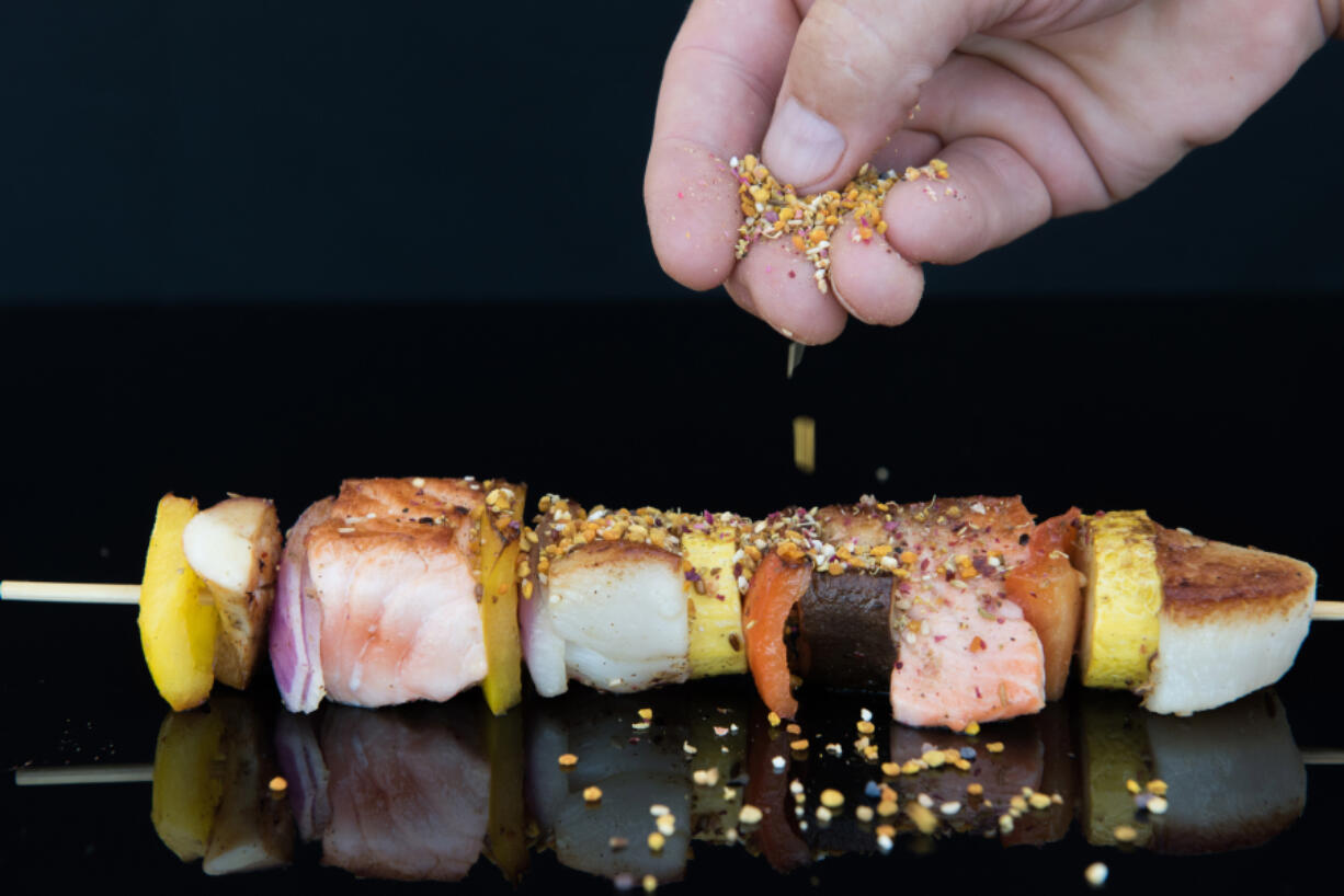 Chef Todd Gray sprinkles his version of manna on a seafood kebab at Manna, Gray’s restaurant in the Museum of the Bible in Washington, D.C. Dixie D.