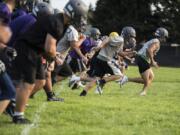 Heritage players run conditioning drills during a practice at Heritage High School on Thursday night, Aug. 16, 2018.