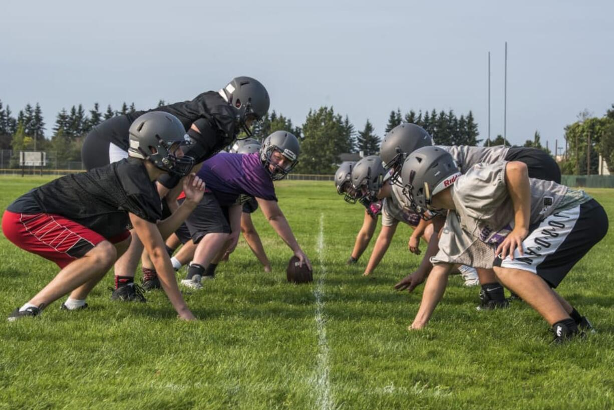 Heritage linemen perform a snapping drill during a practice. The Timberwolves return eight starters on defense.