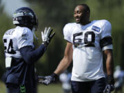 Seattle Seahawks linebackers Bobby Wagner, left, and K.J. Wright, right, talk during NFL football training camp, Sunday, July 29, 2018, in Renton, Wash. (AP Photo/Ted S.