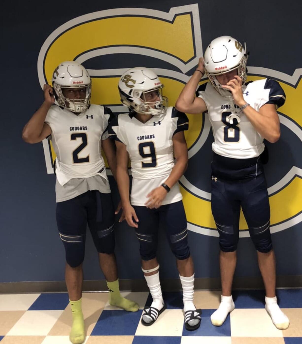 Seton Catholic players (left to right) Tyvauntae Deloney. Taj Muhammad and Mikey Silveira Jr. try on the game uniforms for the first time of the 2018 football season on Thursday at Seton Catholic College Prep.