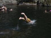 Swimmers dive into the action at Dougan Falls as temperatures hover around 100 degrees July 15, 2018.