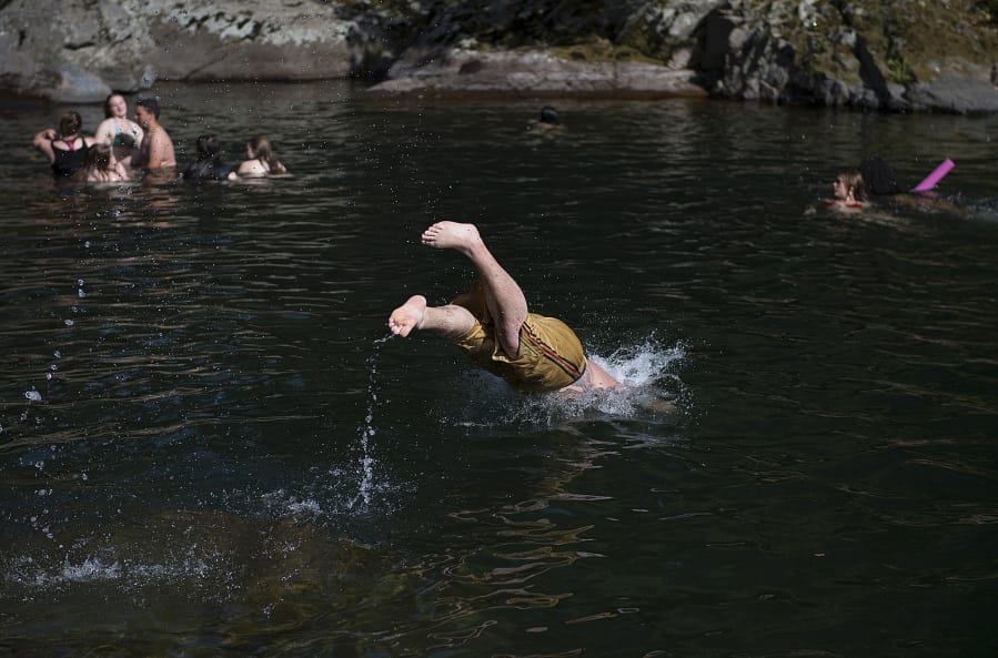 Swimmers dive into the action at Dougan Falls as temperatures hover around 100 degrees July 15, 2018.