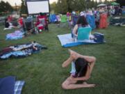 Mariella Bibian, 9, of Vancouver shows her flexibility while waiting with the crowd for the start of the movie “Wonder Woman” at Columbia Tech Center Park on July 27, 2018. The film, which was freec, is part of the Movies in the Park series hosted by the city of Vancouver.