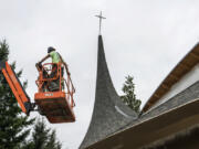 A contractor working at Vancouver United Church of Christ prepares to install new windows on July 19. The church’s west steeple was damaged by fire in May 2016.