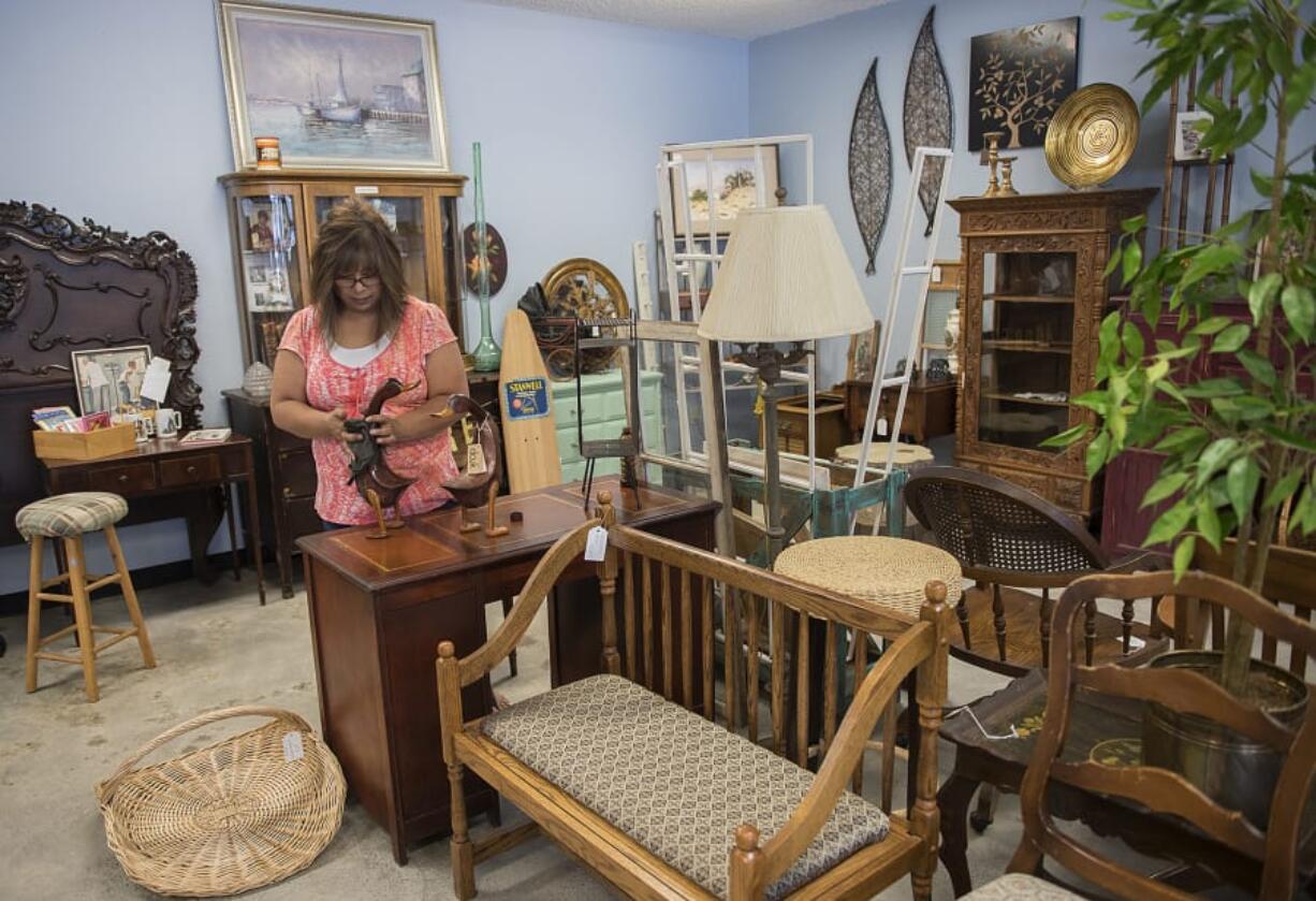 Annette North, co-owner of Rusty Gold in Orchards, polishes a pair of hand-carved, vintage ducks. The store is the revenue arm for the Clark County Christian Center, which had to close its previous thrift store This-N-That. “We’re getting back on our feet,” North said.