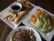 The Camas Carver, clockwise from top, is served with the chipotle chicken wrap and the New York Balsamico at The Oaks Bar & Grill earlier this month.