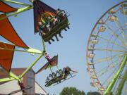 Hailey Hartzell, top from left, Maya Hartzell, and Connor McKay, all of Monroe, Wash., take the Cliff Hanger for a spin while enjoying the rides at the Clark County Fair on Monday afternoon, Aug. 6, 2018. The trio said they were having fun showing their cows at the annual event, which lasts through Aug. 12.