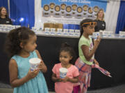 Janaye Bol, 6, of Graham, left in blue, escapes from the heat with a cold cup of water with her sisters, Adrienne, 4, and Mackensie, 9, at the Clark Public Utilities booth at the Clark County Fair on Thursday afternoon. Janaye said she was having a good time at the fair despite the heat and appreciated having the free fans and water to cool off.