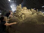 Sand sculptors Sue McGrew, from left, Brian Thomas and Brandi Glenn put details on a 75-ton sandcastle Saturday in the Grand Pavilion at the Clark County Fair. Brandi Glenn and her husband, Greg Glenn, own Sandscapes, a California-based sandcastle-building company.