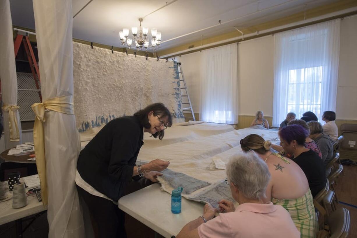 Vancouver native Janice Arnold, left, a leading felt artist and the creator of what she thinks is surely the largest single slab of handmade felt in America, leads a felt embroidery workshop at the Providence Academy building. Visitors learned about the history of feltmaking and stitched silk images of local maps by Arnold’s late father, cartographer Phil Arnold, into the border of her Monster Felt.