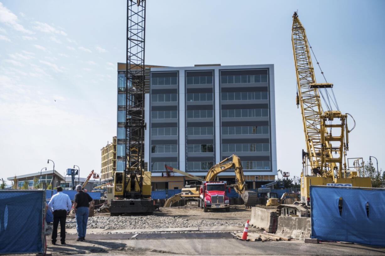 Dean Kirkland, chairman of Kirkland Development LLC, left, oversees work on a two-floor underground parking garage that will serve Hotel Indigo at The Waterfront Vancouver development on Monday afternoon. Set to open in 2020, the hotel is part of a huge swell in Vancouver’s tourism capacity expected to increase by 30 percent in five years.