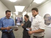 Campaign manager Wyatt Arnall, from left, Democratic candidate for the 3rd Congressional District Carolyn Long and campaign consultant Parker Butterworth react to the election results at the Clark County Public Service Center on Tuesday night (Nathan Howard/The Columbian)