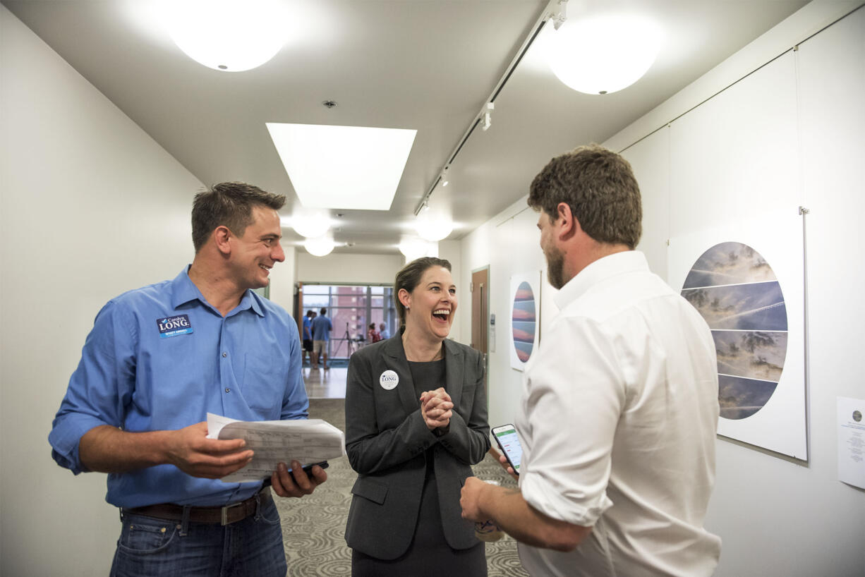 Campaign Manager Wyatt Arnall, from left, Carolyn Long, Democratic candidate for the 3rd Congressional District, and Campaign Consultant Parker Butterworth react to the election results at the Clark County Public Service Center on Tuesday night.