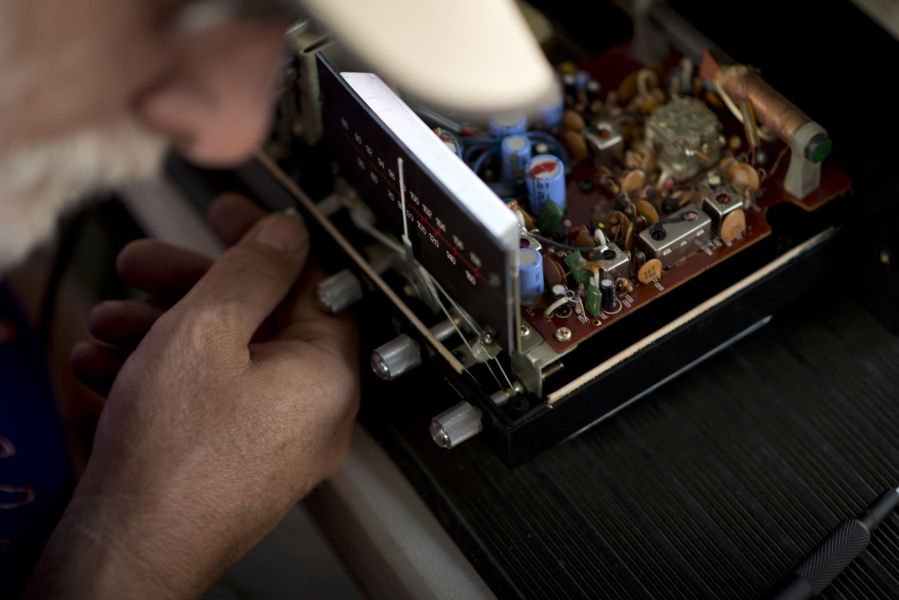 Volunteer Mike Farabee of Vancouver, a retired design engineer, tries to repair Kathy Roussos’s decades-old radio, which once belonged to her mother. Farabee had to send Roussos away with the name of a part to buy, and she promised she would; she said she’s determined to fix the radio, rather than replace it.