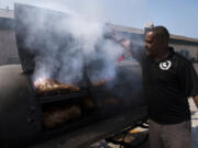 Donnie Vercher, owner of Daddy D’s Southern Style BBQ, checks on brisket and pulled pork he’s smoking in preparation for the restaurant’s grand opening today. Vercher is opening his first standalone restaurant after having a location in the back of a Shell station in Vancouver for the last 10 years.