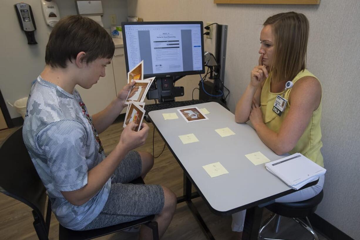 Jack Bellamy, 15, of Ridgefield, left, uses sequencing cards during cognitive therapy with speech language pathologist Melissa Bohnstedt at PeaceHealth Southwest Medical Center in Vancouver.