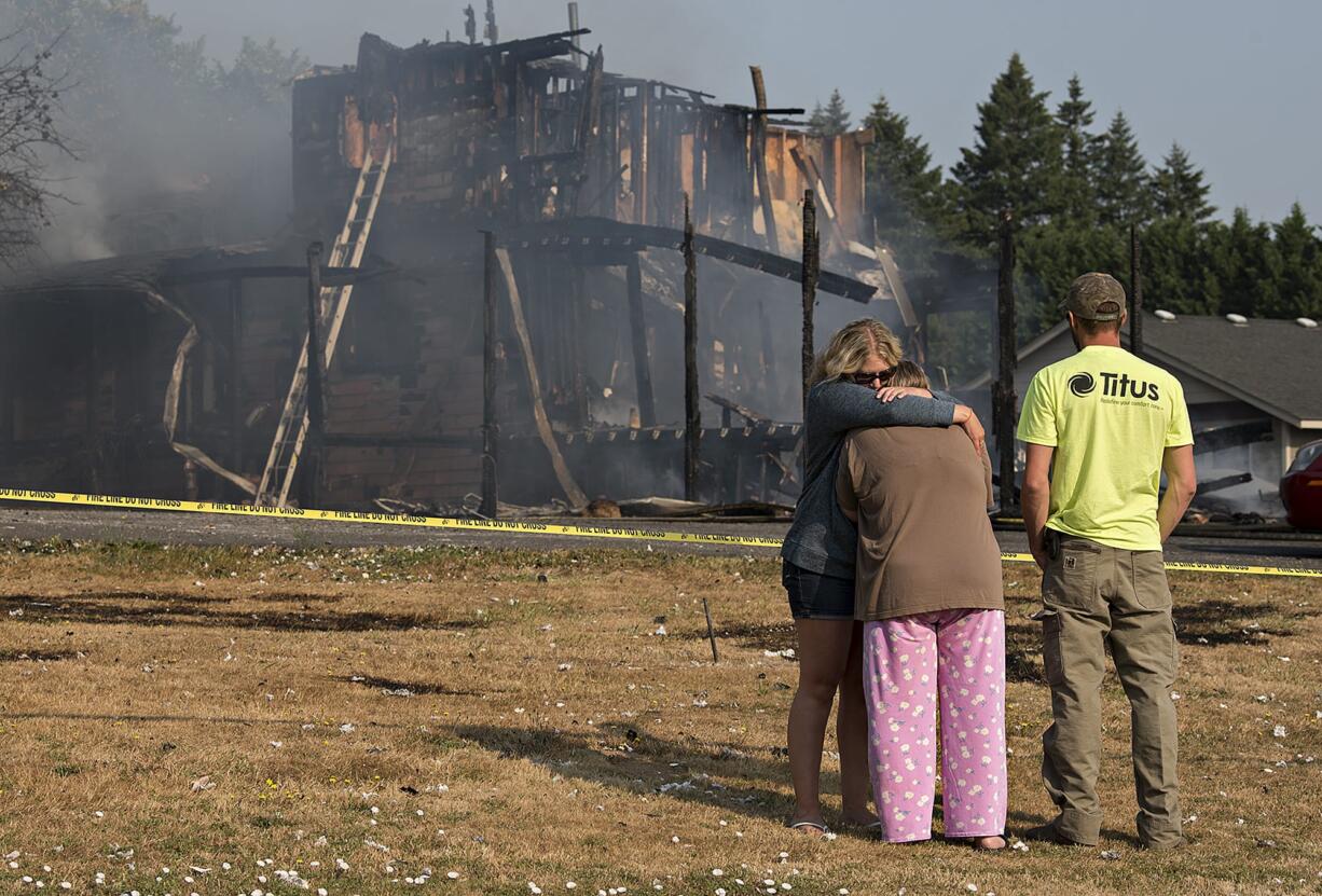 Samantha Casteel of Vancouver, left, hugs Paula Cutler of Vancouver, center, the mother of the woman killed in a Ridgefield house fire last Wednesday morning with Jimmy Casteel of Battle Ground.