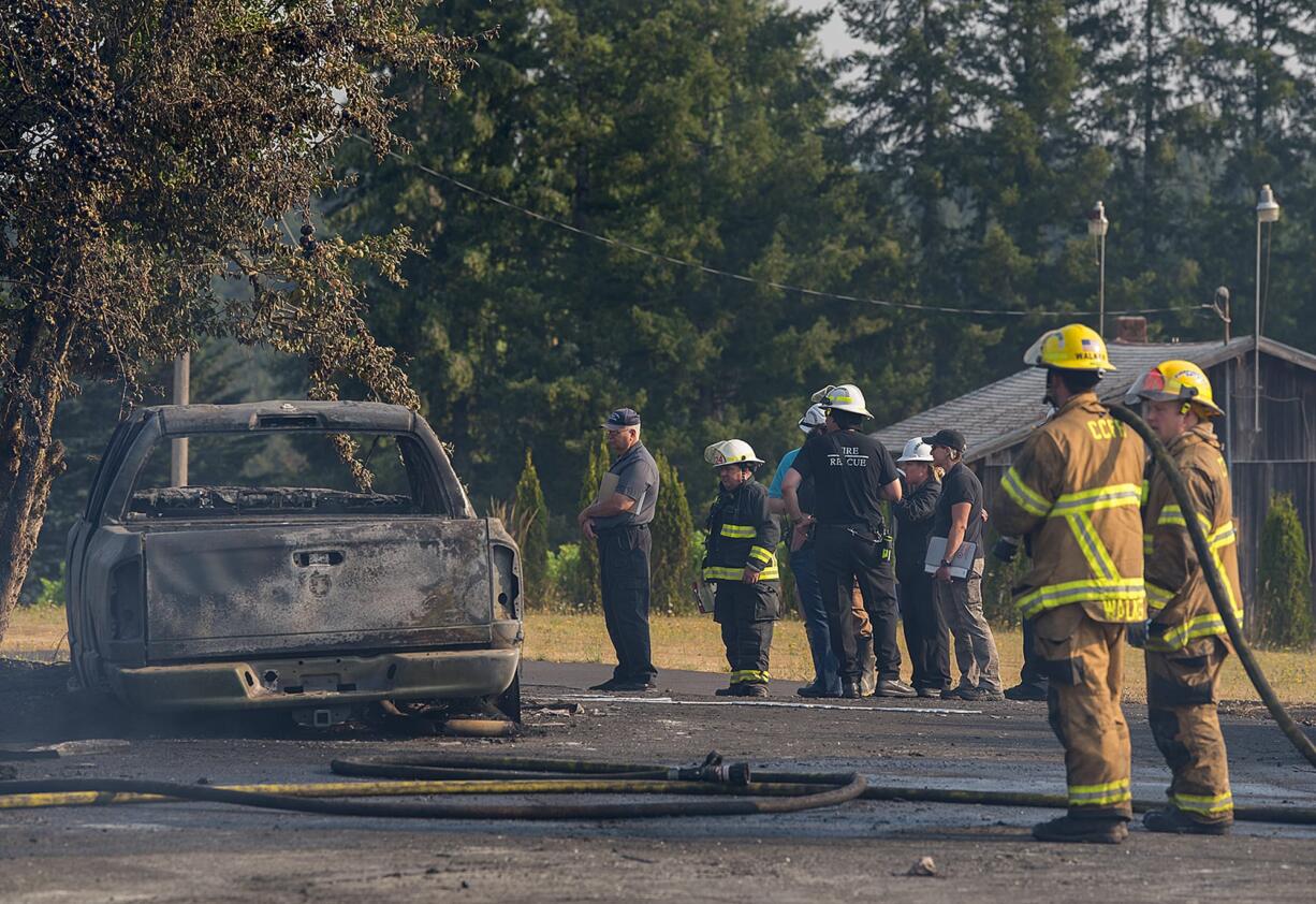 Firefighters work at the scene of a house fire in Ridgefield where a woman and a dog are reported missing Wednesday morning.