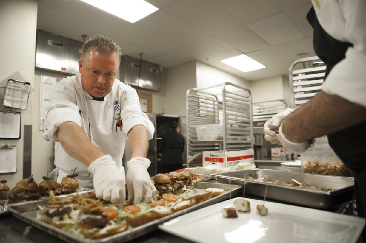 Executive chef Troy Lucio prepares miniature pub burgers before the ribbon-cutting ceremony at the Hilton Vancouver Washington’s Grays Restaurant on Thursday afternoon. The restaurant was celebrating a menu redesign and renovation focusing on a more casual, Northwest dining experience.