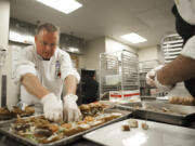 Executive chef Troy Lucio prepares miniature pub burgers before the ribbon-cutting ceremony at the Hilton Vancouver Washington’s Grays Restaurant on Thursday afternoon. The restaurant was celebrating a menu redesign and renovation focusing on a more casual, Northwest dining experience.